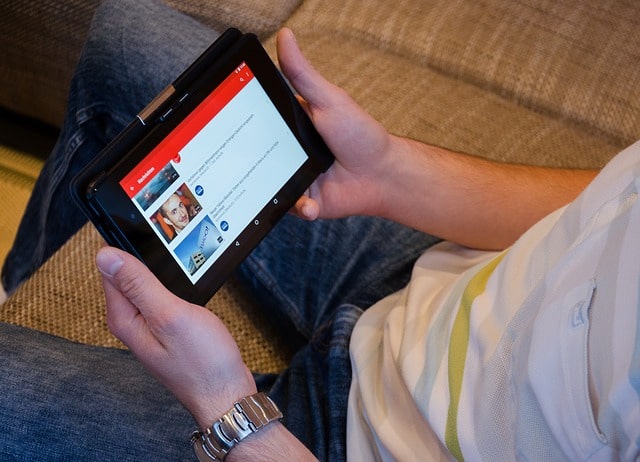 A Person holding Ipad with youtube open