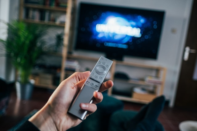 A person is setting the Smart TV with his Remote